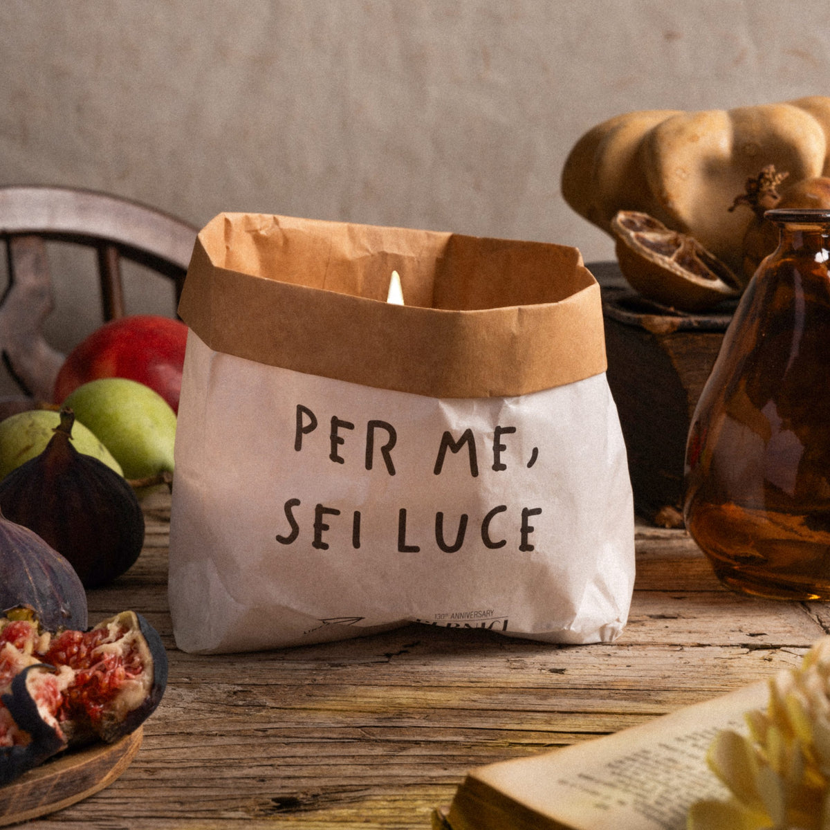 Candela profumata in sacchetto di carta con la scritta “Per me sei luce”, che diffonde una fiamma calda e accogliente, fragranza Bergamot & Orange Blossom.
